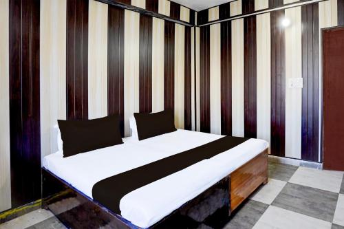 a bed in a room with a striped wall at Hotel O Govind Guest house in Jhājra