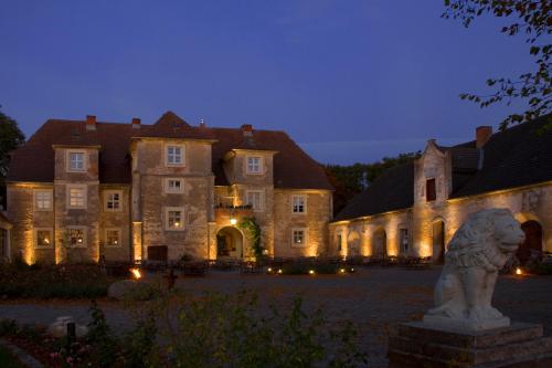 a large building with a lion statue in front of it at Hotel Wasserschloss Mellenthin in Mellenthin
