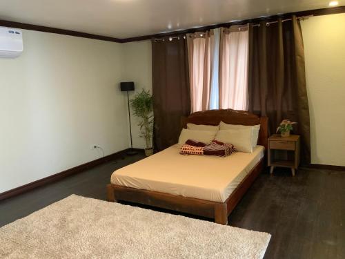 een slaapkamer met een bed in een kamer met twee tapijten bij Montego Lakeview House with Taal View in Ulot