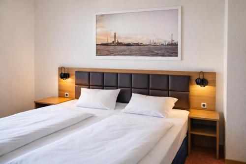 a bedroom with a large bed with white sheets at Dancenter Hotel Jomfru Ane in Aalborg