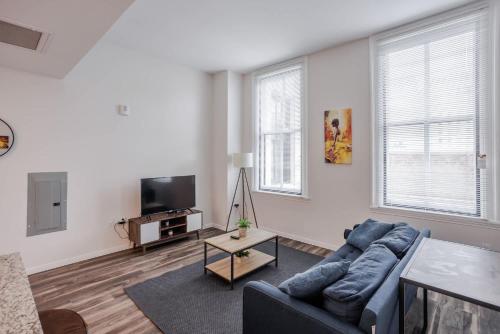 a living room with a blue couch and a tv at CozySuites at Sky Central in Cincinnati