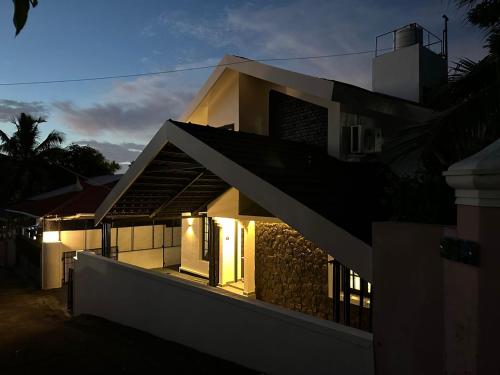een huis met lichten aan de zijkant bij Asramom Home in Kollam
