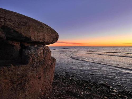 a sunset over the ocean with a rocky beach at Apartment in a farmhouse with 2 swimming pools in Cagli