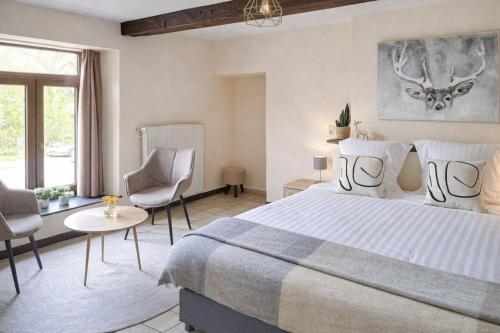 ein Schlafzimmer mit einem großen Bett und zwei Stühlen in der Unterkunft Au Coeur d'Alle by Belvilla in Alle