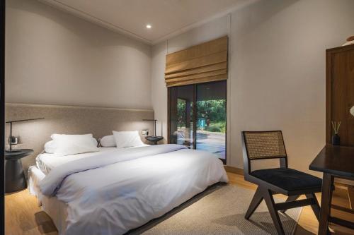 a bedroom with a large bed and a desk and a chair at Your Luxury Villa in the South of Jakarta in Samporo