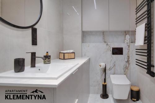 a white bathroom with a sink and a toilet at Klementyna in Bystra