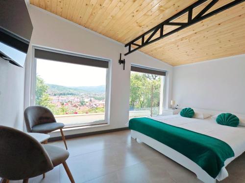 een slaapkamer met een bed en een groot raam bij Epic Glamping in Călimăneşti