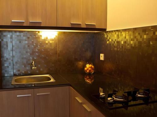 a kitchen with a sink and a counter top at Eazy Suite Legian in Seminyak