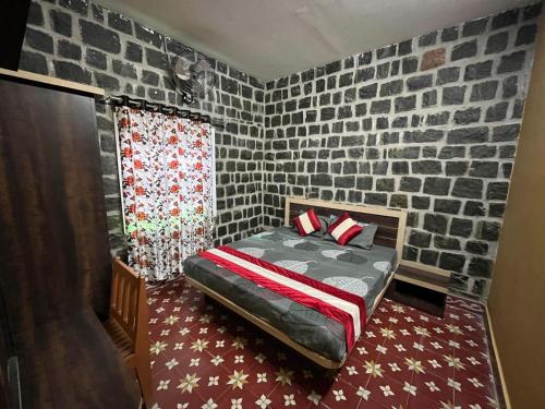 a bedroom with a bed with a brick wall at Honeycomb Abode in Salem
