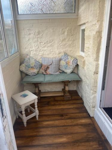 a cat sitting on a bench in a tiny house at Country cottage in Springwell