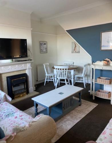 a living room with a table and a fireplace at Country cottage in Springwell