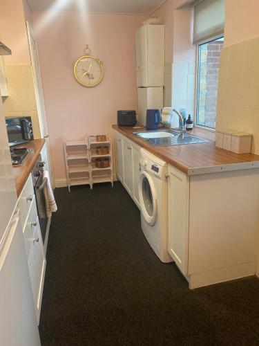 a kitchen with a sink and a washing machine at Country cottage in Springwell