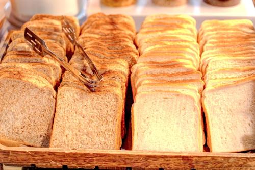 un mucchio di panini tostati in un cestino con delle pinze di Manchester Portland By Sunday a Manchester