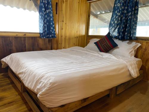 a bedroom with a large bed with blue curtains at Friendly Homestay & Authentic Trekking Tours in Sapa