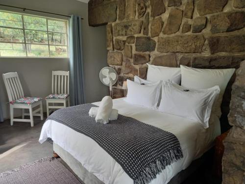 a bed with a teddy bear sitting on top of it at Springwater Cottages in Ficksburg