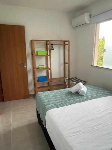 una camera da letto con un letto e una libreria di Conforto e Aconchego em Imbassaí/BA a Imbassai