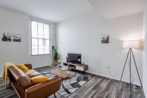 a living room with a couch and a tv at CozySuites Sky Central #22 in Cincinnati