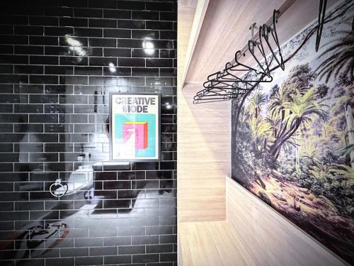 a bathroom with a black brick wall and a picture at Z Loft Seaside FutureJungle Loft in Nathon Bay