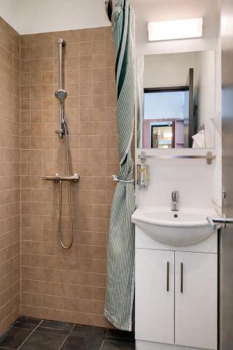ein Badezimmer mit Dusche und Waschbecken in der Unterkunft Dancenter Hotel Jomfru Ane in Aalborg