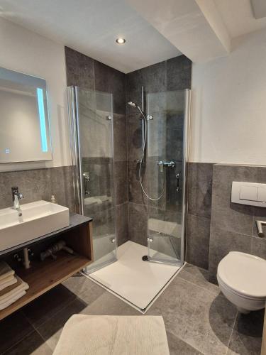 a bathroom with a shower and a toilet and a sink at Reiterhof in Westendorf