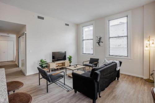 een woonkamer met een bank, stoelen en een tv bij CozySuites Sky Central #4 in Cincinnati