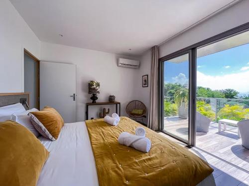 een slaapkamer met een groot bed met twee handdoeken erop bij Sea view beach access path ! in Saint-François
