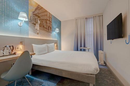 a hotel room with a large bed and a chair at Manchester Portland By Sunday in Manchester