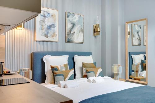 een slaapkamer met een bed met een blauw hoofdeinde bij Charmant et central - Neuilly in Neuilly-sur-Seine