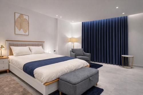 een slaapkamer met een bed en een stoel bij Abu Rakan Apartment in Muscat