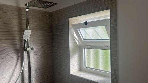 een badkamer met een douche, een raam en een spiegel bij Casa Primavera in Carvoeiro