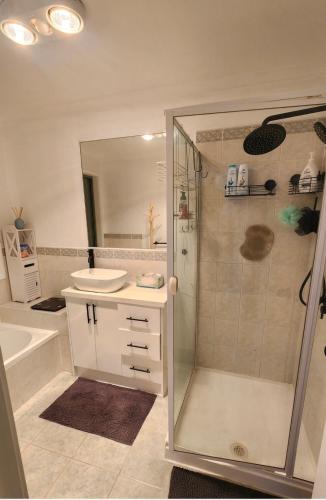 a white bathroom with a sink and a shower at Private Room with a view, close to everything in Sydenham