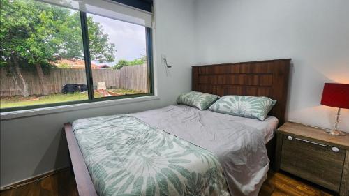 a small bedroom with a bed and a window at Private Room with a view, close to everything in Sydenham