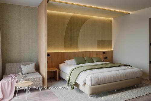 ein Schlafzimmer mit einem großen Bett und einem Stuhl in der Unterkunft Hotel Garden Istra Plava Laguna in Umag