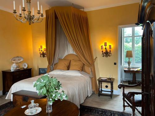una camera da letto con un letto a baldacchino e un tavolo di Château de La Tour en Brenne a Rivarennes