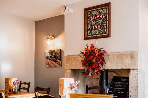 een eetkamer met een open haard en een tafel bij The Railway in Skipton