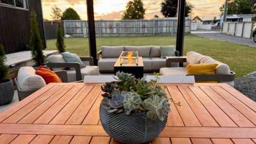a patio with a wooden table with plants on it at The Mango Shed in Mangakino