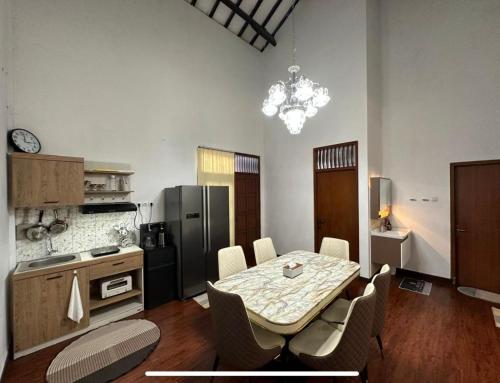eine Küche mit Tisch und Stühlen und einem Kühlschrank in der Unterkunft Puri Sagan in Yogyakarta
