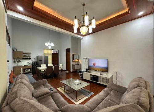 ein Wohnzimmer mit Sofa und Fernseher in der Unterkunft Puri Sagan in Yogyakarta