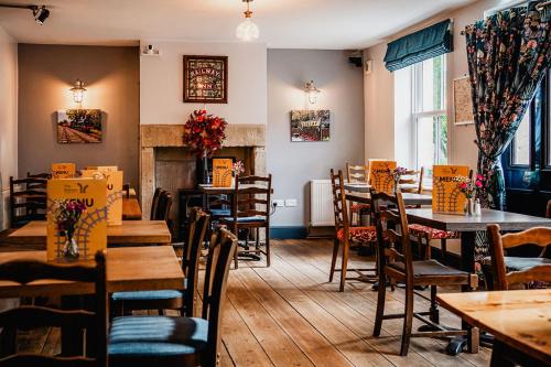 een restaurant met tafels en stoelen en een open haard bij The Railway in Skipton