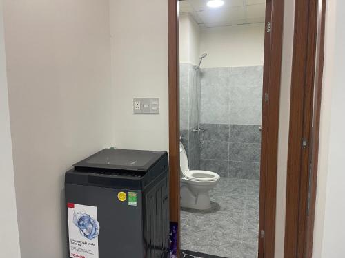 a bathroom with a toilet and a trash can at HomeDubai in Kinh Dinh