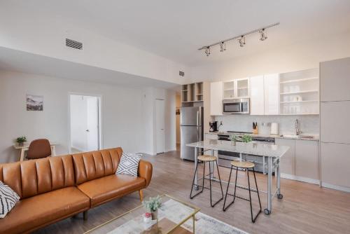 een woonkamer met een bank en een keuken bij CozySuites Sky Central #20 in Cincinnati
