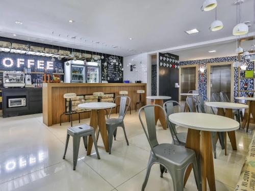 un ristorante con tavoli, sedie e un bancone di ibis Styles Vitoria da Conquista a Vitória da Conquista