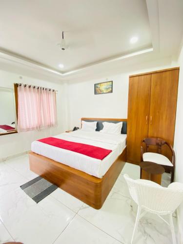 a bedroom with a large bed and a chair at Rama Grand Palace in Ayodhya