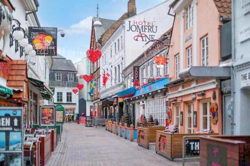 a street in a town with many shops at Dancenter Hotel Jomfru Ane in Aalborg