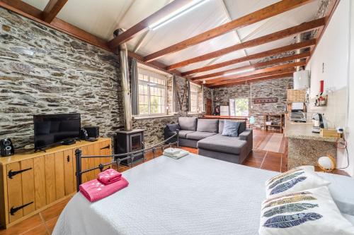 een kamer met een bed, een tv en een bank bij Casa da Passagem in Vila Real