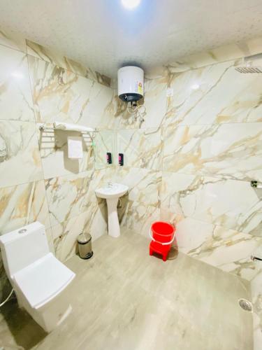a bathroom with a white toilet and a sink at Rama Grand Palace in Ayodhya