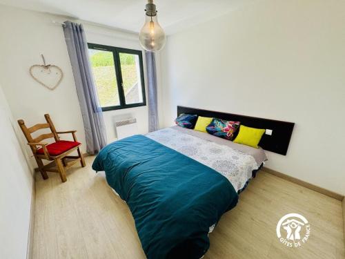 a bedroom with a bed and a chair and a window at Nore & nature in Pradelles-Cabardès