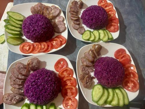 quattro piatti di diversi tipi di alimenti su una tavola di Pá Hideaway - Thác Bản Giốc- Cao Bằng a Trùng Khánh