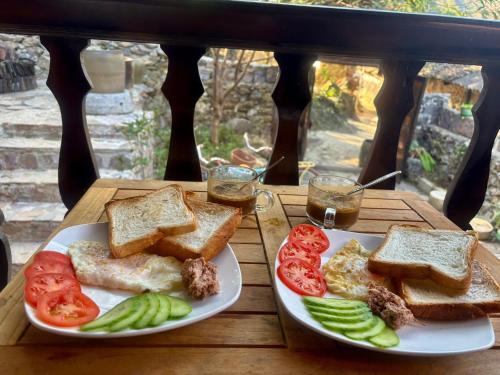 un tavolo di legno con due piatti di pane tostato e verdure di Pá Hideaway - Thác Bản Giốc- Cao Bằng a Trùng Khánh