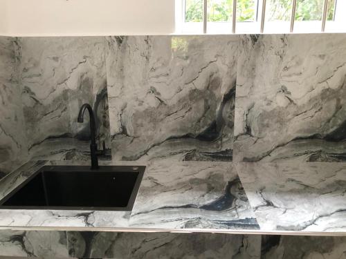 a bathroom with a sink and a marble wall at The BLISS Mihiripenna in Talpe